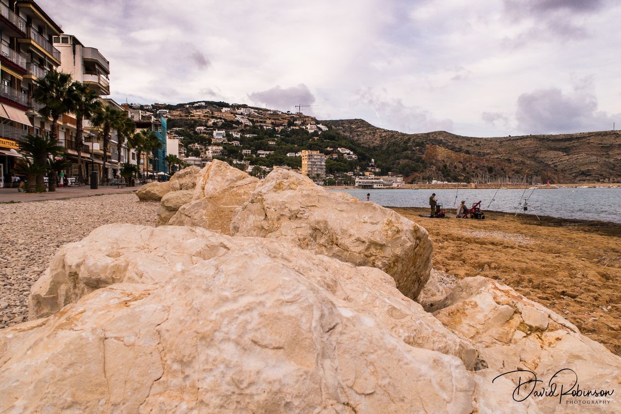 GROUP OF PEOPLE ON ROCKY BEACH