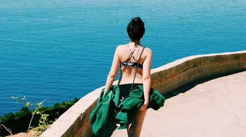 Rear view of woman walking against sea