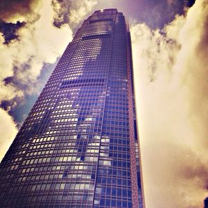 Low angle view of modern building against cloudy sky