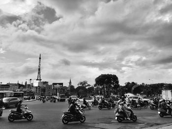 People on street against cloudy sky