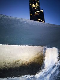 Sea by buildings against clear sky during winter