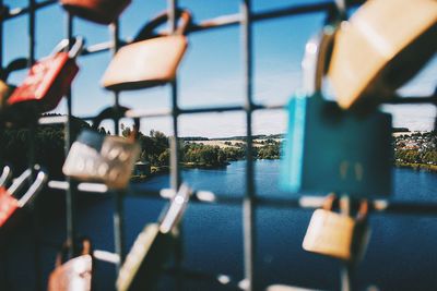 Tilt image of metal hanging by river against buildings in city