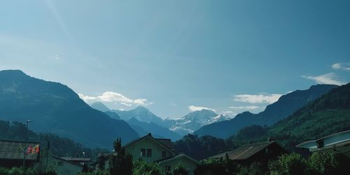 Scenic view of townscape by mountains against sky