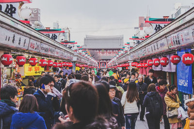 People walking on street amidst stalls at market