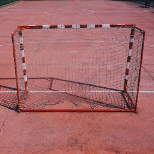 Old soccer goal in the red field on the street