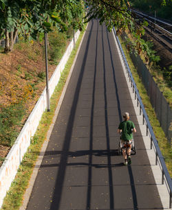 Rear view full length of man walking on footpath