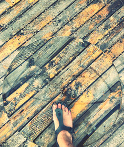 Low section of woman standing on wooden floor