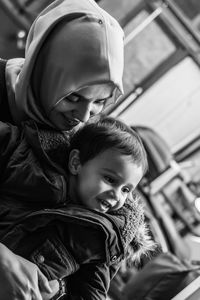 Close-up of smiling mother and son at home