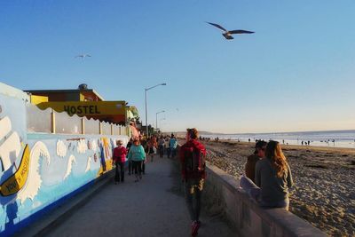 People at beach against clear sky