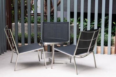 Empty chairs and table in yard