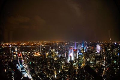 Illuminated cityscape against sky at night