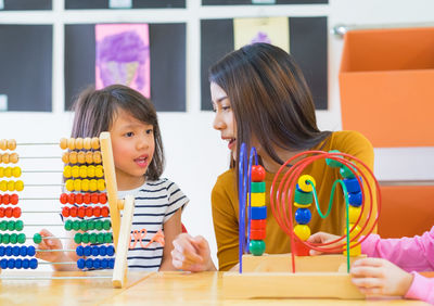 Mother and daughter playing with toys at home