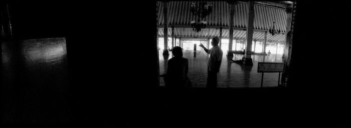 Silhouette people walking in corridor of building