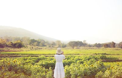 Woman standing on field against clear sky