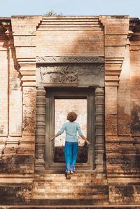 Full length rear view of woman walking in building