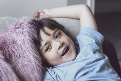 Smiling boy leaning on sofa at home