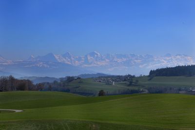 Scenic view of field and mountains against sky