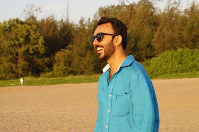 Smiling man wearing sunglasses at beach