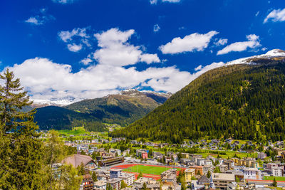 Scenic view of townscape and mountains against sky