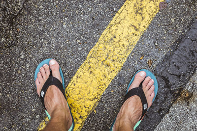 Low section of man standing on road