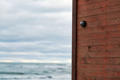 Ip cctv camera with home security system installed on wooden wall against backdrop of seascape