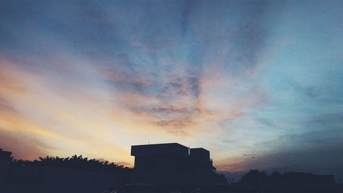 Low angle view of silhouette city against sky during sunset
