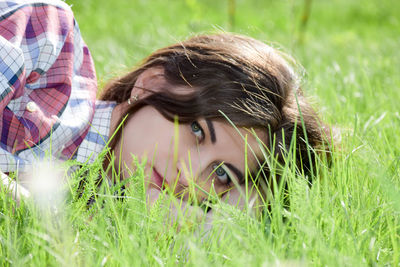 Portrait of young woman on grass in field