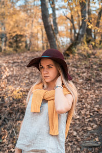 Portrait of beautiful young woman standing in park during autumn