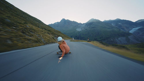 Rear view of woman walking on road