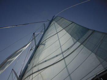 Low angle view of sailboat against clear blue sky