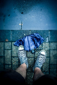 Low section of man standing by water