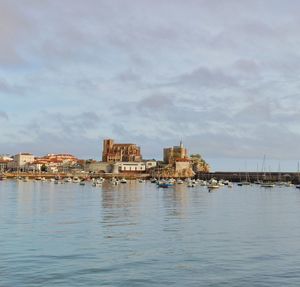 Buildings by sea against sky in city