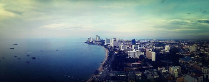 Aerial view of cityscape against cloudy sky