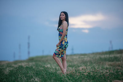 Woman standing on field against sky