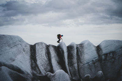 Man on rock against sky