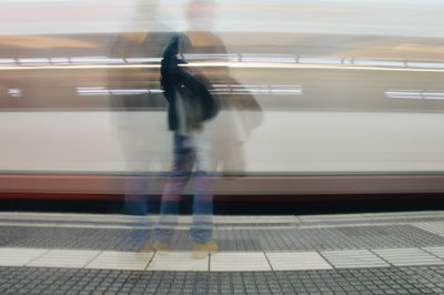 Blurred man waiting at railway station platform