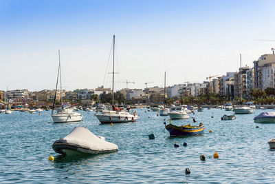 Boats moored on sea against clear sky