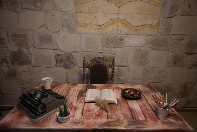 Old bottles on table against wall
