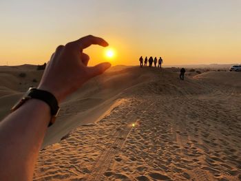 Optical illusion of woman hand holding sun at beach