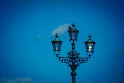 Low angle view of lamp post against blue sky