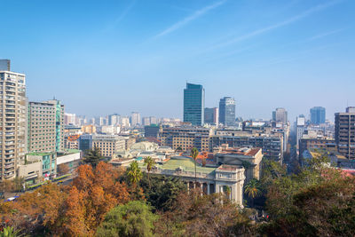 High angle view of cityscape against blue sky during sunny day