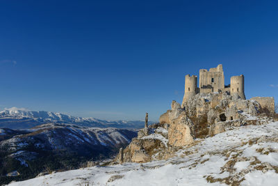 Snow covered mountain against blue sky