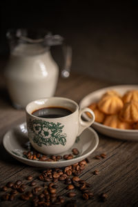 Kuih bahulu with a cup of coffee on wooden table. malaysian snacks. asian foods.