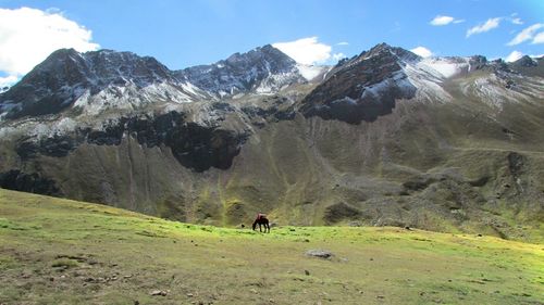 Man walking on snowcapped mountains against sky