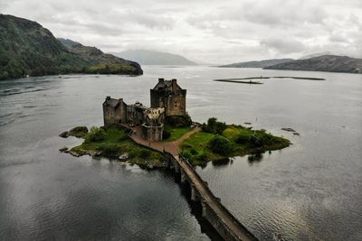 Scenic view of sea by castle against sky