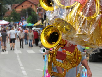 Person selling trumpets while walking on street in city