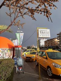 Cars on street in city against sky