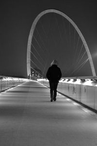 Rear view of silhouette man walking on road