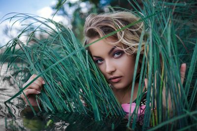 Portrait of young woman against plants