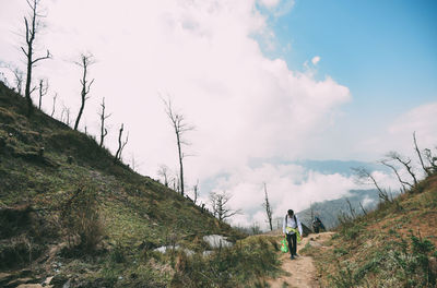 Rear view of man walking against sky